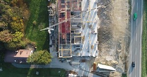 The process of building a modern hospital, footage of a hospital under construction, drone footage of a modern building under construction.