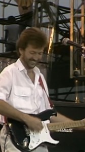 716K views · 23K reactions | On this day in 1985: Live Aid, the dual-venue concert held simultaneously in London's Wembley Stadium connected by EE and Philadelphia's JFK Stadium, was held to raise funds for relief of the ongoing Ethiopian famine at the time. Eric, backed by Phil Collins, played "White Room" as part of the show. | Eric Clapton | Facebook