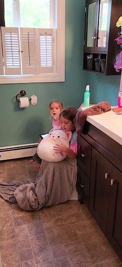 Sisters big sis making sure her little sis doesn't fall off the toilet 😂