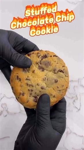 Stuffed Chocolate Chip Cookie A decadent twist on a classic favorite, this oversized chocolate chip cookie is crisp on the outside, soft and gooey inside, and generously stuffed with a rich, velvety ganache. Bursting with melty chocolate chips in every bite,irresistible dessert for cookie lovers. Warm it up for the ultimate ooey-gooey experience! #chocolatechipcookie #stuffedcookie #cookie #alittlecake #bakery | A Little Cake