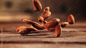 Almonds from a tree are dropping onto a hardwood table, creating a natural event within a landscape of plantbased materials