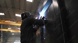 slow motion of working class Indian male welding metal iron pieces for truck trailers production in factory company in Asia