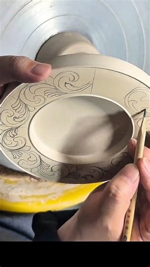 Hand engraving floral motifs on ceramic plate