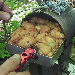 Camping Oven! Sideways Firebox Billy Pot & Firebox Baking Pans! The patented handle clips on our exclusive billy can bush pot makes the pot lid into an oven door! Baked yummy camping treats or roast beef for Sunday dinner! Firebox out door cooking gear makes cooking out a uniquely fun experience! #firebox #fireboxstove #cookout #fieldkitchen #campcooking #campcook #campingofficial #campfirefood #woodcooking #campfirecooking #crockpotcooking #onepotmeal #bushcraft #bushcooking #campfire #woodsman