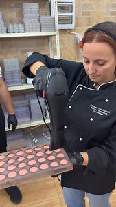 Before applying the final layer (the cap) to a chocolate mold, we often use a heat gun to gently warm and seal the borders of the already formed chocolate shell. Warming the edges slightly helps to soften the surface so that the final layer bonds more securely and creates a strong seal. This technique reduces the risk of gaps or weak seams between the shell and the cap, and helps the chocolate layers integrate smoothly as they set. Practically, you move the heat gun across the edges until they b