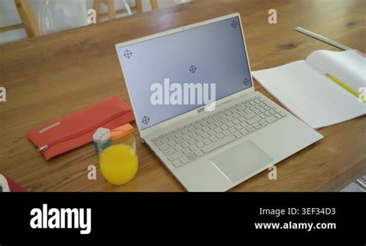Operator is starting slow handheld pan toward white laptop on table, framing screen markers. Computer, desk, kitchen, daylight, notebook, pencil, glass Stock Video Footage - Alamy