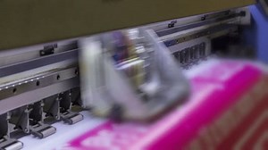 Time lapse of Large format inkjet printer printing with pink color on vinyl paper in workplace