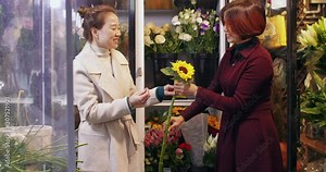 middle age asian woman shopping flowers in the florist shop Chinese florist working in the shop talking with clients picking flowers together