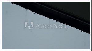 Rain and roof. Falling rain from the roof. Rain drops flow down from a roof down. Raindrop pouring off roof on rainy sky daytime. Weather forecast. Represent lazy and relax or chill out mood tone.
