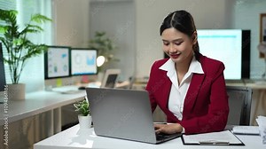 Asian businesswoman sitting in office looking at detailed graphs on laptop, PC computer, chart of real estate growth data, online financial documents in modern office. Stock Video