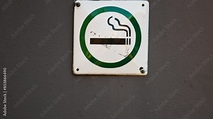 Capturing a slow motion closeup video of a smoking area sign intended for designated smokers in a public space