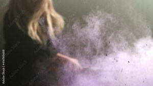 Woman smashes a computer screen with a crowbar in slow motion with colorful paint powder