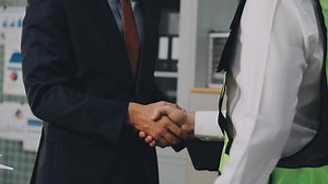 Download Two men shaking hands in an office for free
