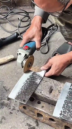 The man is sharpening the knife and the man is sharpening the knife using a grinding machine