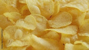 Macro view of potato chips spinning close up. Golden fried potatoes, Junk food