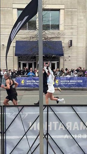 Runners dressed as bride and groom compete in the 2026 Boston Marathon