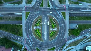 Aerial time-lapse of car traffic at roundabout, drone top down view.