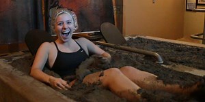 People are bathing in vats of mud