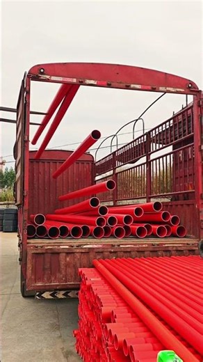 Efficiently Loading Vibrant Red Pipes onto a Large Transport Truck