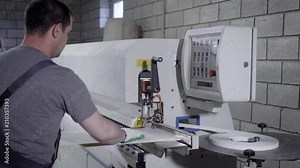master is using industrial machine for processing edges of particle board in workshop of furniture plant