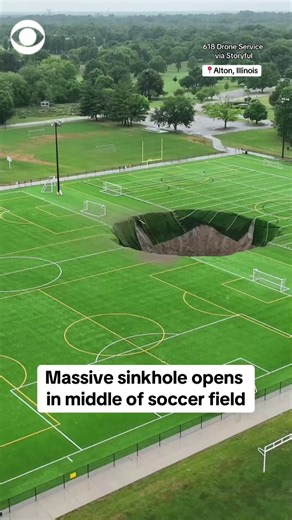 701K views · 8.4K reactions | Drone video shows a huge sinkhole – estimated to be at least 100 feet wide and 30 feet deep – that opened up in the middle of a soccer field in Alton, Illinois, this week. No one was hurt or on the field at the time of the collapse. https://cbsn.ws/4eEnYLP | CBS News | Facebook