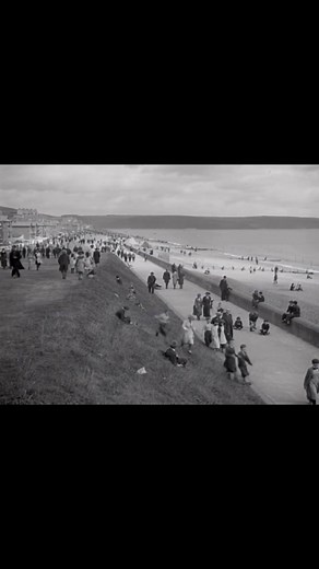 The promenade and beach at Youghal, County Cork, Ireland, taken in the 1920s Youghal is a historic walled seaport and seaside resort town located on the estuary of the River Blackwater. The area shown is likely the Front Strand or Claycastle Beach, which are popular sandy beaches near the town center. The town has been a tourist destination since the mid-19th century and is known for its long stretches of Blue Flag beaches. Today, a 1.9km eco-boardwalk connects the various beaches, providing a p