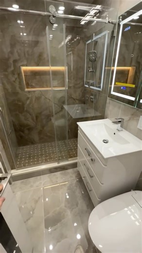 ABCPROCONSTRUCTION on Instagram: "A sleek bathroom transformation ✨ Modern marble-look tiles, a frameless glass shower, and clean-lined fixtures create a calm, spa-like atmosphere. Built-in shower niche with soft lighting adds both function and elegance, while the glossy floor enhances light and space. Minimalist. Timeless. Designed for everyday comfort. #abcproconstruction #renovation #repair #construction #bathroom #bathroomrenovation #modernbathroom #spabathroom #bathroomdesign #glassshower #