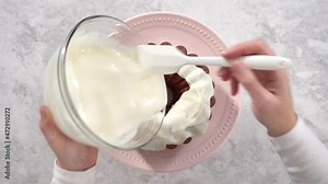 Flat lay. Step by step. Glazing red velvet bundt cake with cream cheese frosting.