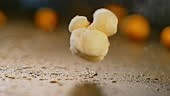 Slow motion close up locked down shot of a corn kernel popping and...
