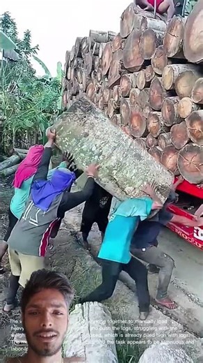 Team Effort: Men Manually Load Heavy Logs onto Truck
