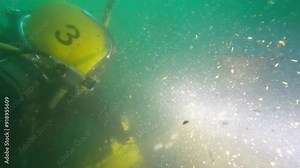 Commercial diver cutting log underwater with chainsaw Stock Video