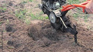 Powerful cultivator, Tiller. Gardening. Spring work on the farm. Land cultivation with a Motor ripper. Man plows the ground. Spring soil preparation for seeding. Husbandman, grower. Moto plow working