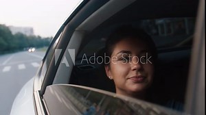 A young beautiful woman rides in a taxi, looks out the open window, enjoys the road. Road, trip, car. Slow motion 4k footage