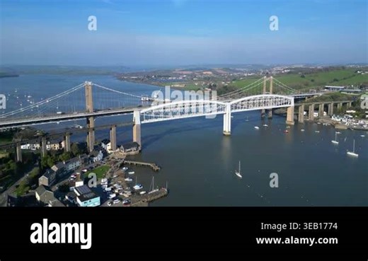 Saltash, Cornwall, England: DRONE VIEWS: The Tamar bridge (road) and the Royal Albert Bridge (rail) spanning the River Tamar. The River Tamar divides the counties of Devon and Cornwall, both of which are popular UK holiday destinations (Clip 7 Stock Video Footage - Alamy