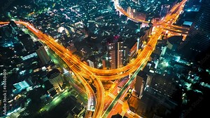 Multi-hour aerial view time-lapse of a massive highway intersection at night in Shinjuku, Tokyo, Japan.