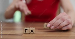 Woman changes word Fact to Fake using wooden cubes at desk. Concept of fact checking to avoid misinformation and media manipulation
