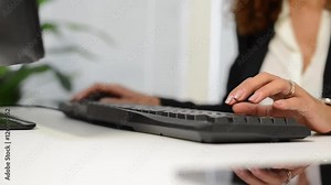 Young secretary typing on her laptop in the office