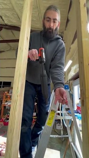 Using the Ramset gun to nail the wall stud to the steel beam.