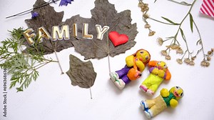 Child modeling people, family from plasticine, clay. Using dry natural leaves, flowers. Colorful modeling clay. Education, playing with clay, sensory perception. Inspiration, imagination