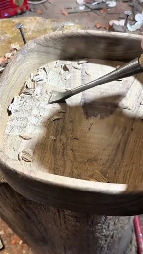 hollow-out a square wooden bowl using a professional curved wood gouge in a woodworking workshop