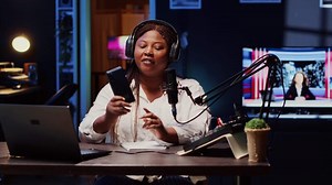 African american tech content creator filming technology review of newly launched smartphone, unpacking it and presenting specifications to audience. Woman showing cellphone to subscribers