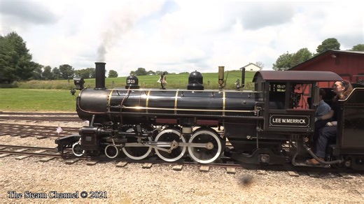 A coach train headed by 1919 steams through the roundhouse area on the Whiskey River Railroad as the Gracy makes her way to the railroad's camp ground stop. | The Steam Channel