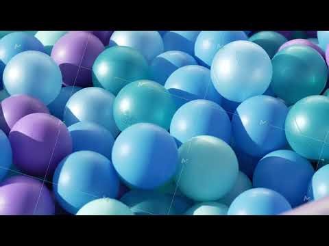 Plastic balls in shades of blue, purple, and green, forming a playful background texture