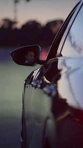 An Urban Evening Drive Featuring a Reflection Visible in the Car Mirror While Driving