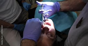 Dentist injects local anesthetic into patient gums. Pre-treatment step essential in dentistry to provide pain relief and reduce sensitivity