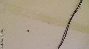 Closeup installation and repair of electric cable, smoke detector, fire alarm system before installing a stretch or suspended ceiling.