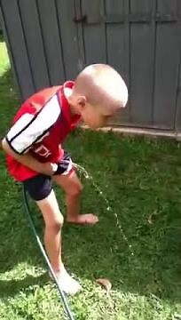 Boy is peeing on dog