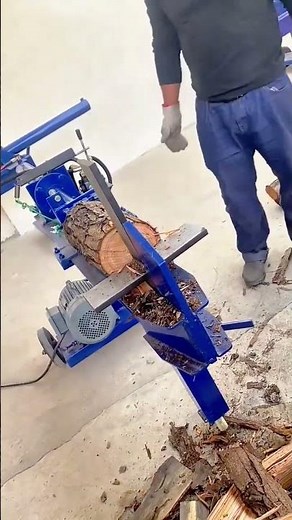 Man Operating a Blue Electric Log Splitter to Process Large Wooden Logs