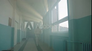 A medical researcher or a scientist walking through a hospital corridor