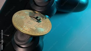 bitcoin. Bitcoin and joystick. gold bitcoin, black gamepad. Slow motion video. High quality video in 4K format.